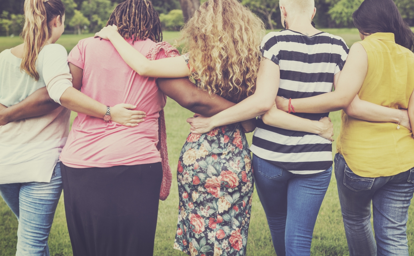 Image of Group of people from behind holding each other with linked arms