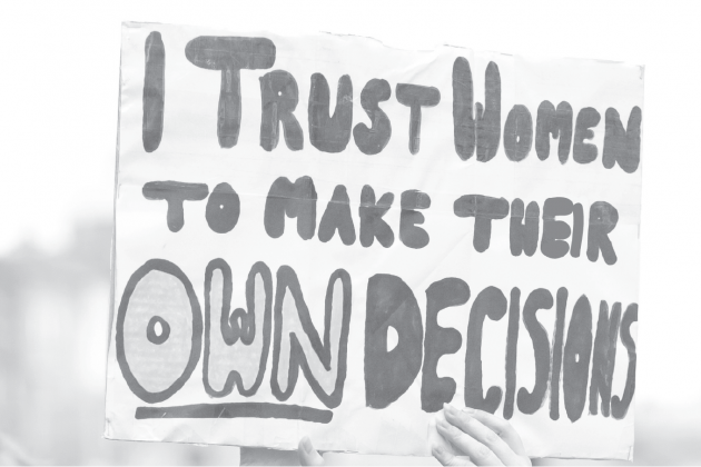 Hand holding rally sign that reads: I trust women to make their own decisions
