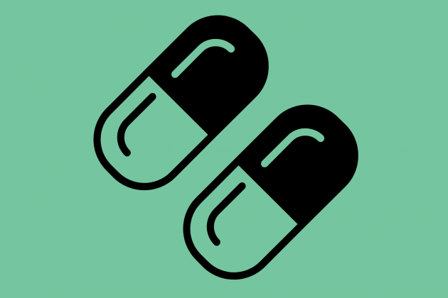 Two pills on a mint green background