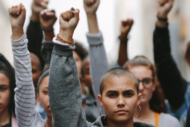 Group of diverse people raising their fists in solidarity. 