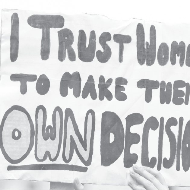 Hand holding rally sign that reads: I trust women to make their own decisions