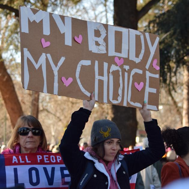 Woman holding up sign during protest that says My Body My Choice