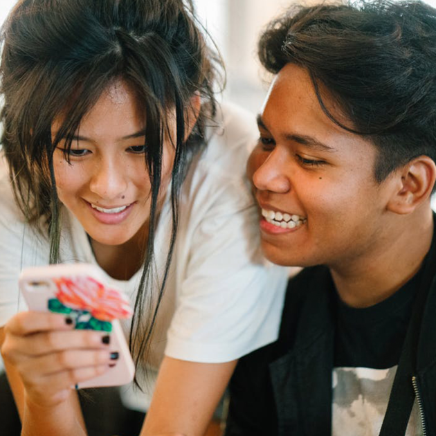 Two people together looking at a cellphone